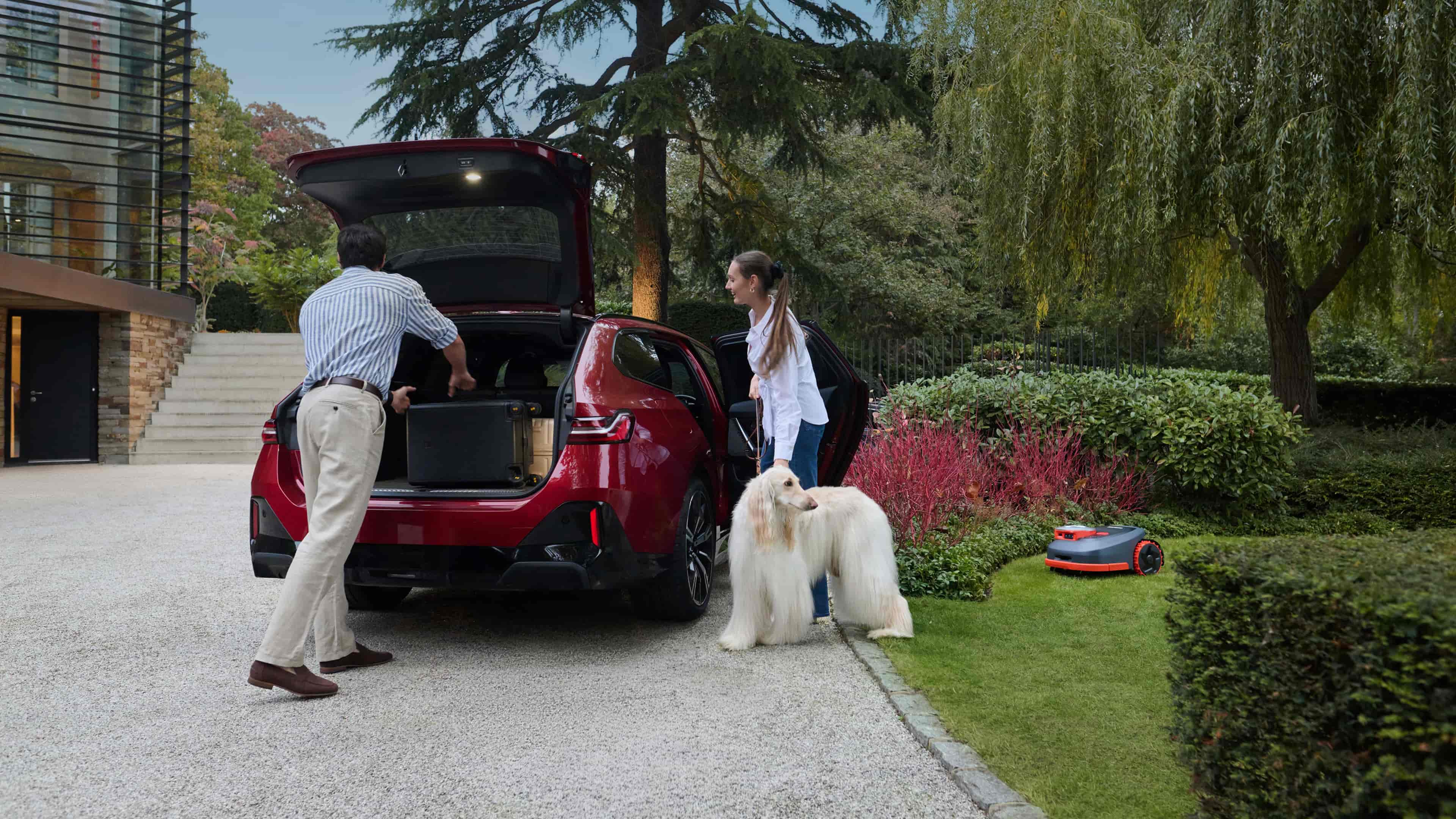 Navimow i110N robot lawn mower works while family packs car.
