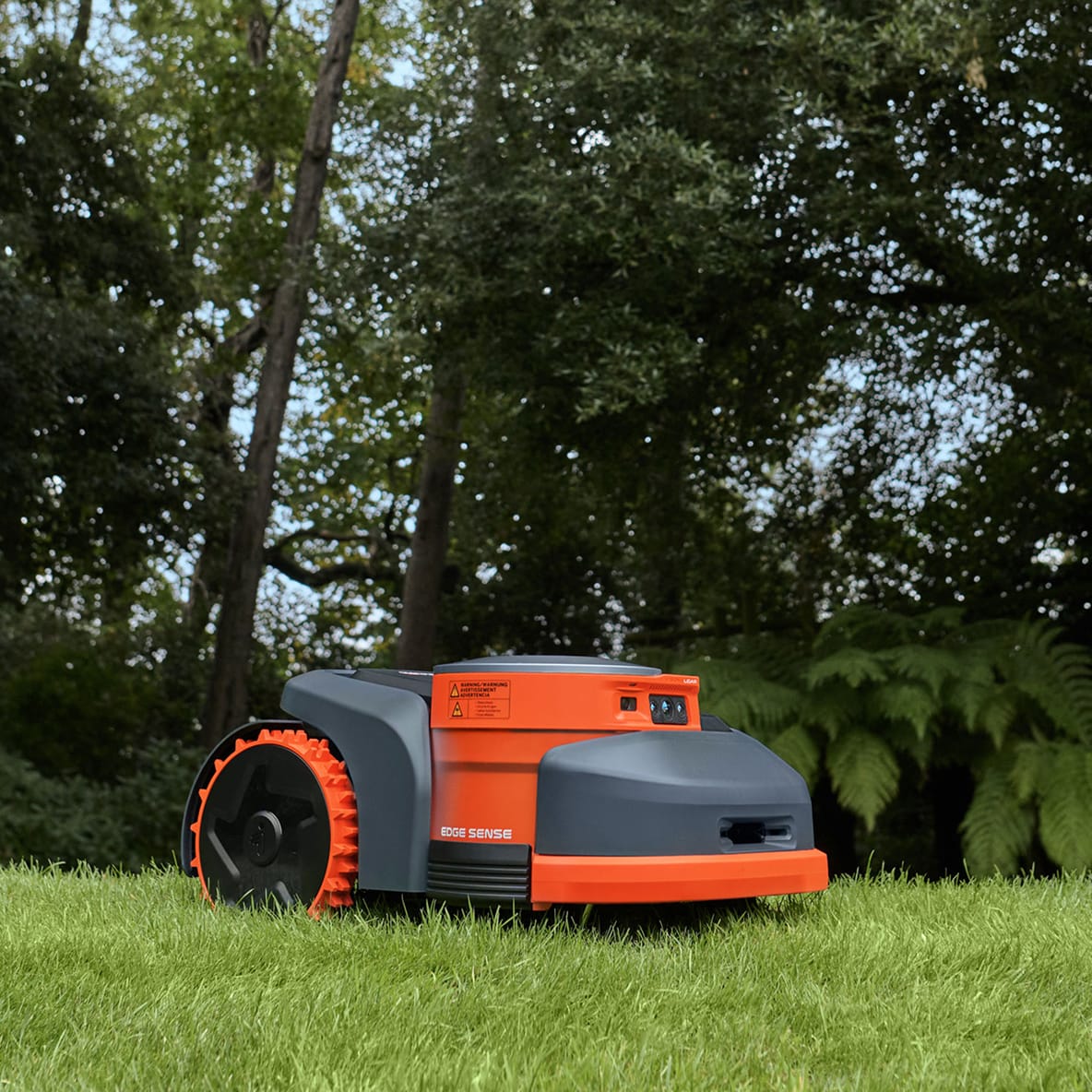 Navimow i110N robot lawn mower is sitting on green grass.