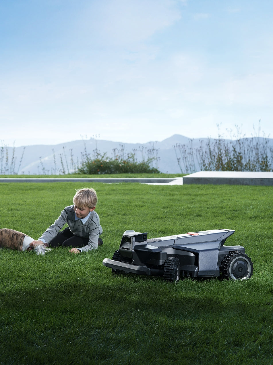 A boy and dog with Navimow i105E robot lawn mower.