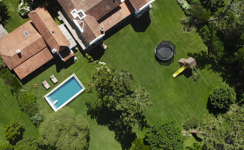 Navimow i110N robot lawn mower mows the large green backyard.