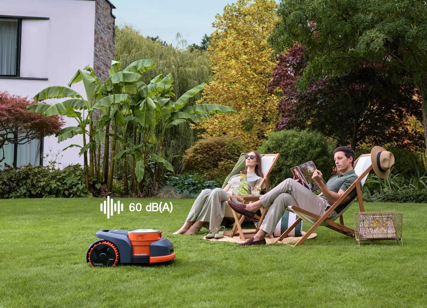Navimow i110E robot lawn mower mows while a couple relaxes.