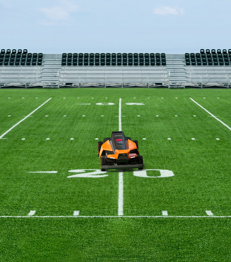 Navimow i110N robot lawn mower on a green football field.