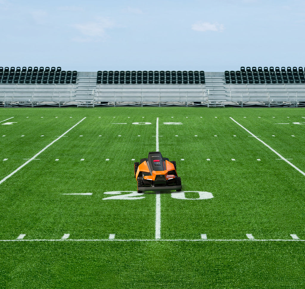 Navimow i110N robot lawn mower on a green football field.