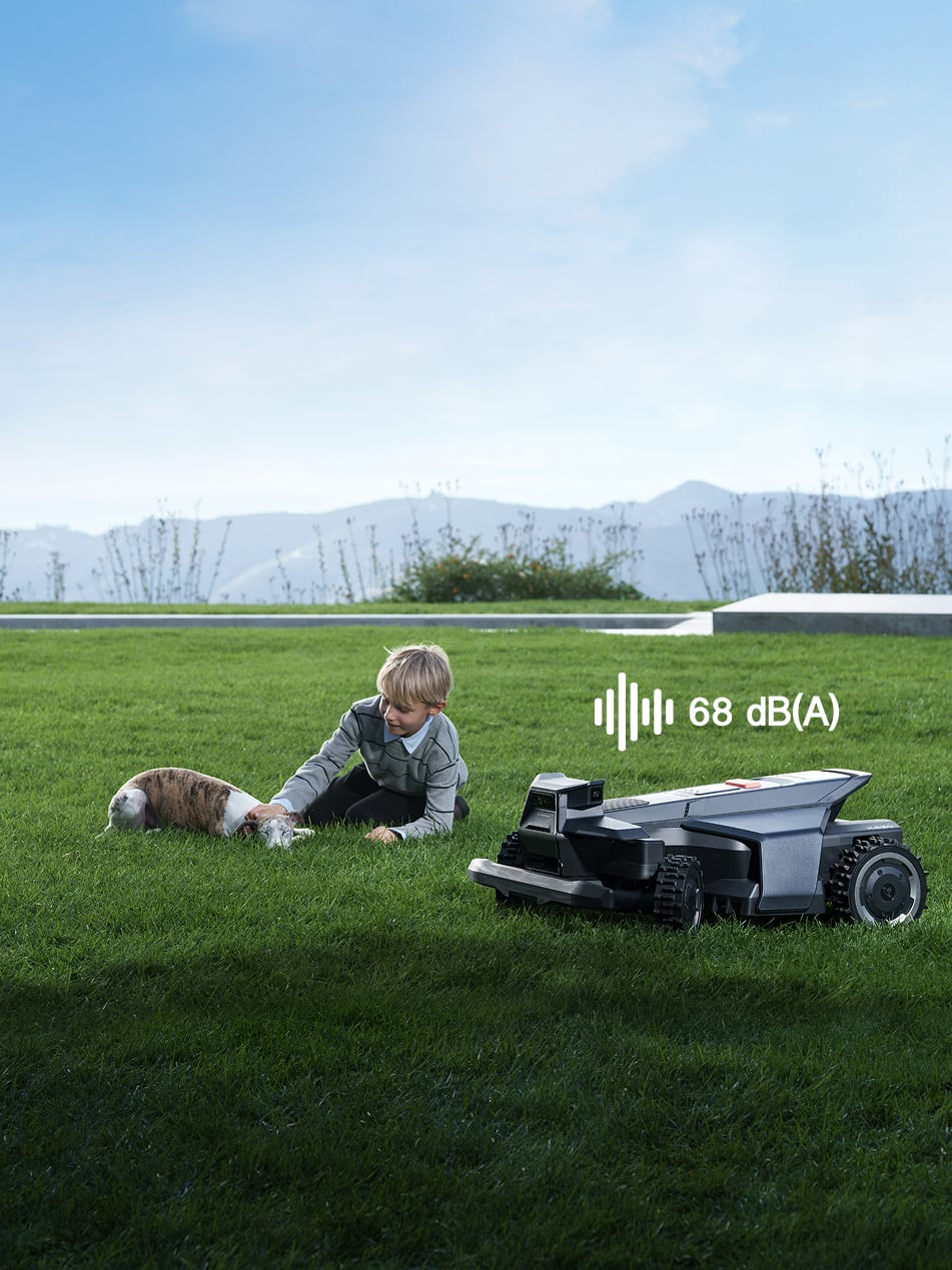 Navimow i110N robot lawn mower with a boy and dog.