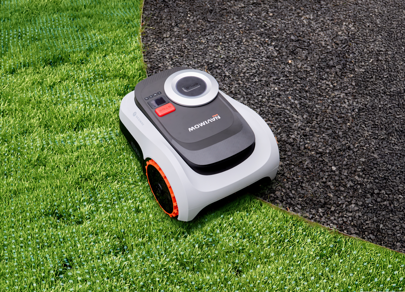 Segway Navimow robot lawn mower on artificial grass and gravel.