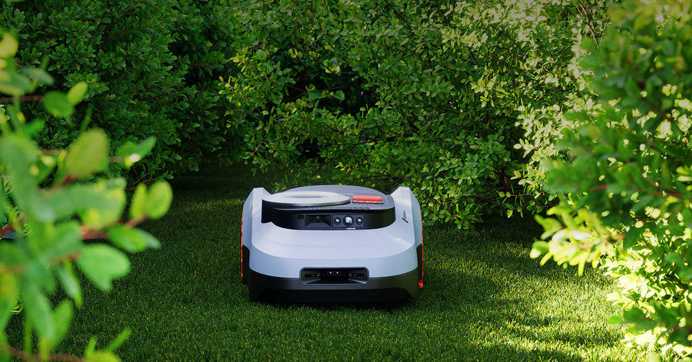 The Navimow i110N robot lawn mower sits on green grass.