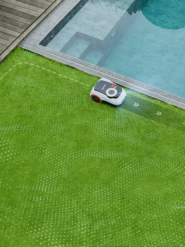 Navimow i105E robot lawn mower is cutting grass near pool.