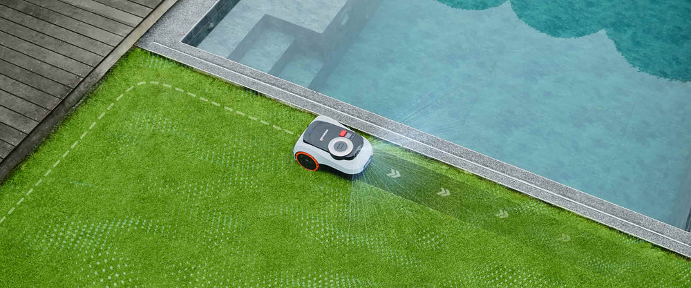 Navimow i105E robot lawn mower mows grass near the pool.