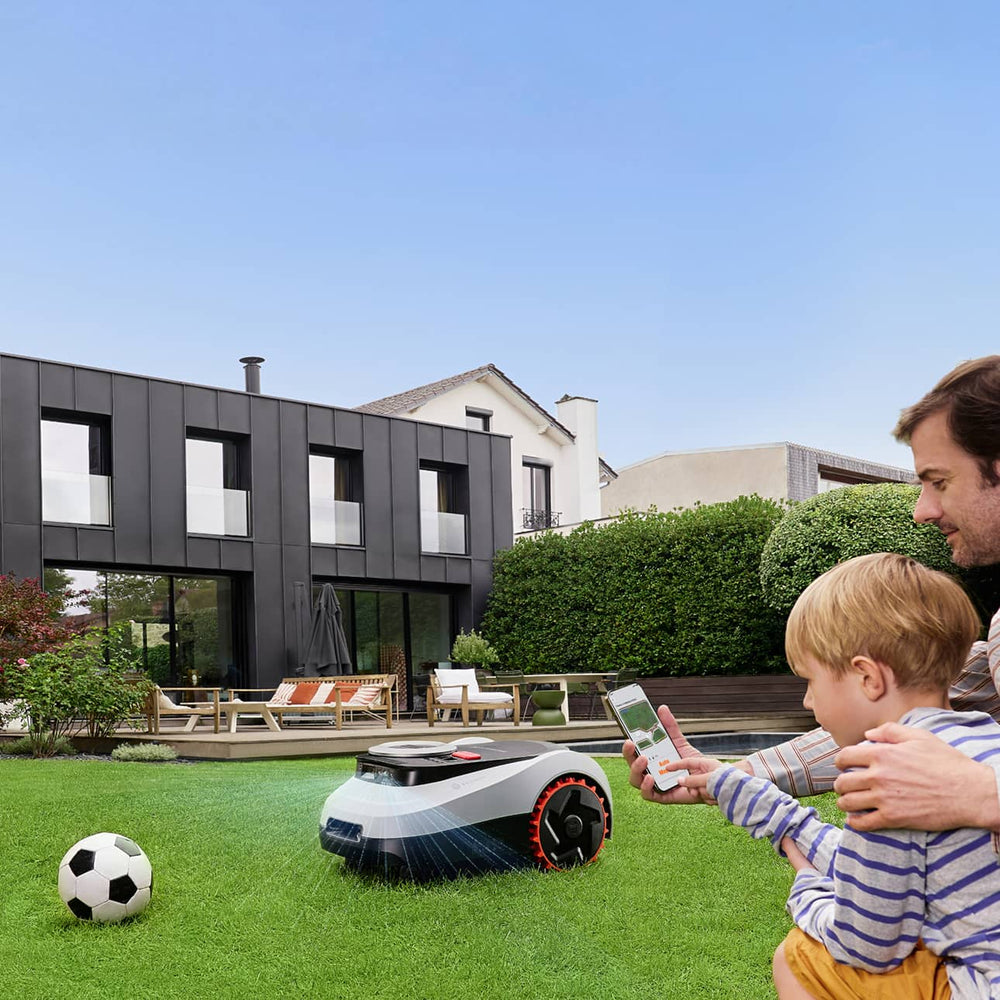 Navimow i110E robot lawn mower mows grass in the backyard.