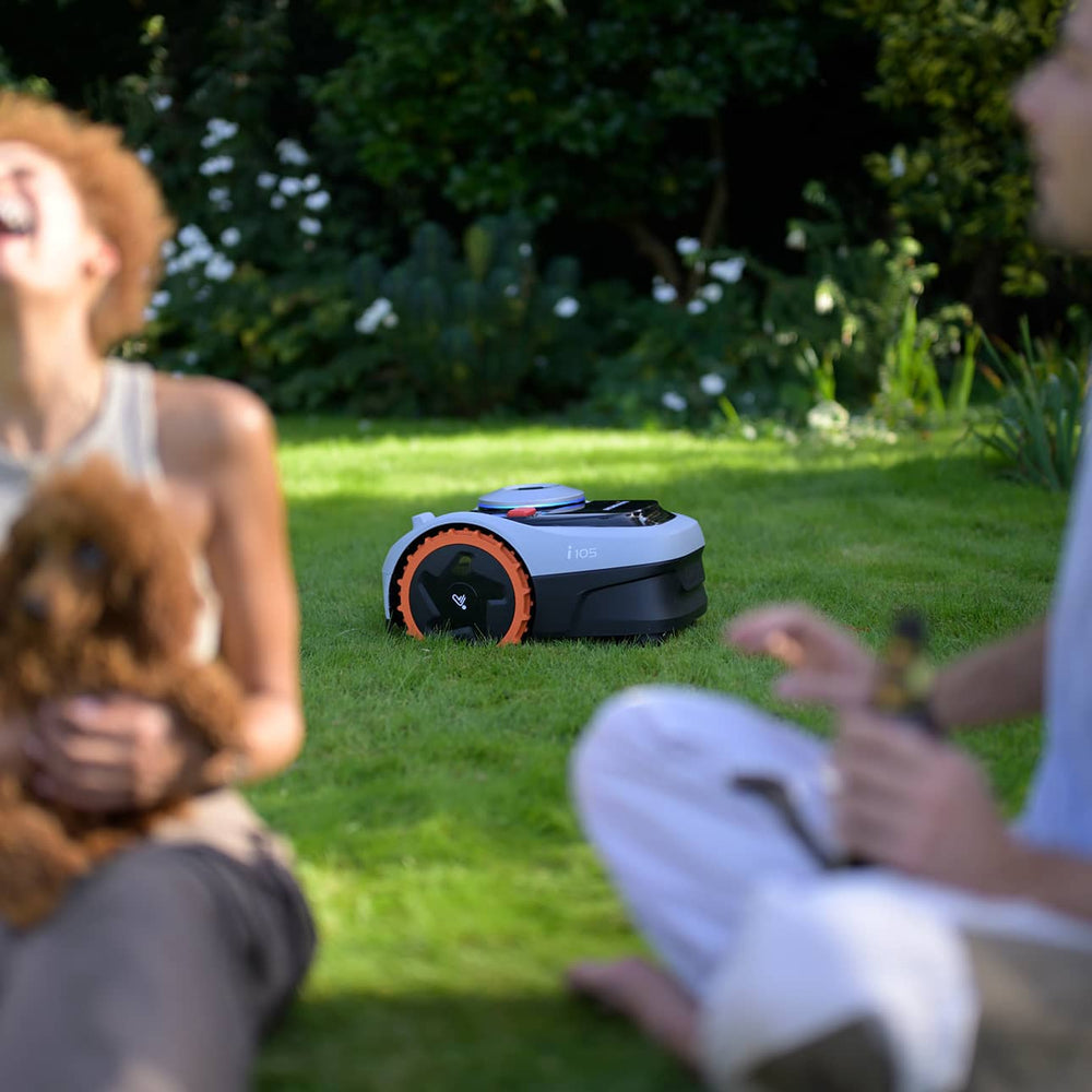Navimow i105 robot lawn mower sits in a sunny garden.