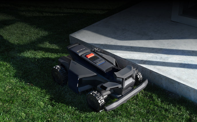 Navimow i110E robot lawn mower parked on the green grass.