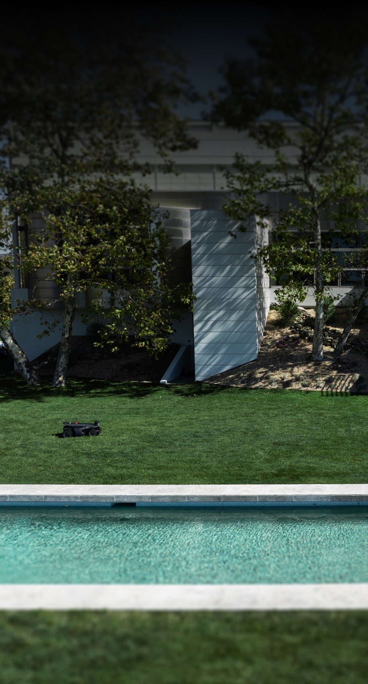 Navimow i110N robot lawn mower mows grass near the pool.